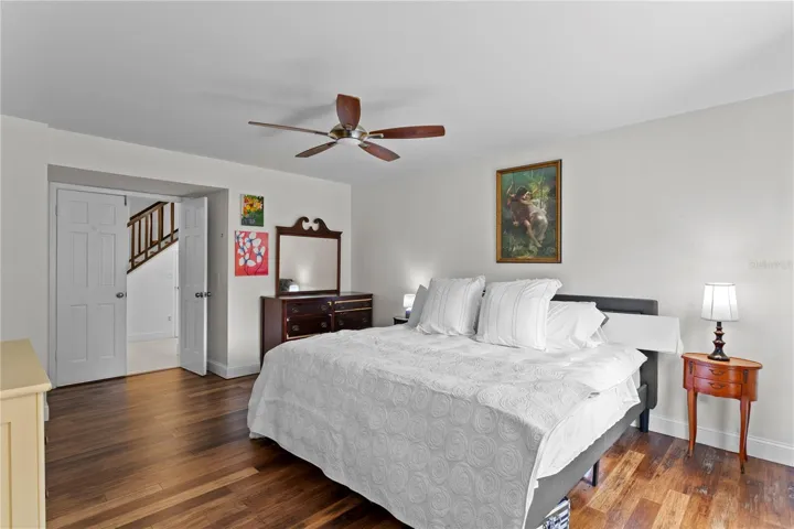 Primary suite features paneled double doors and ceiling fan