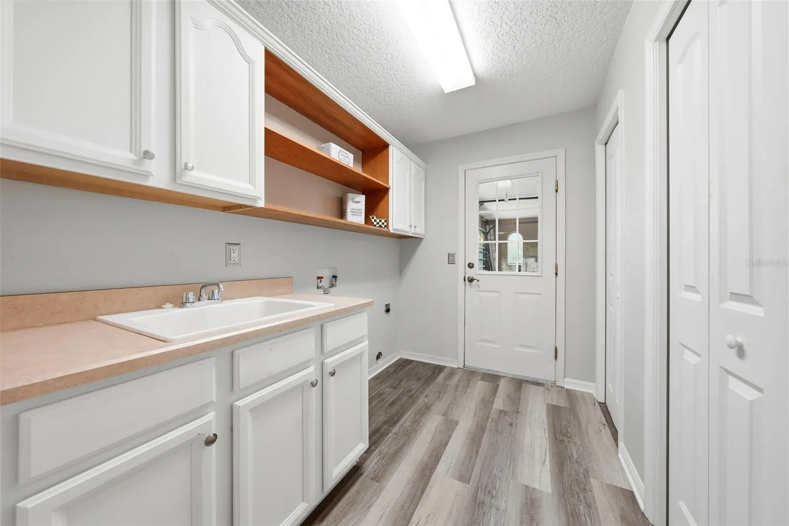 Convenient laundry room located between the kitchen and attached two-car garage for everyday functionality and easy access.