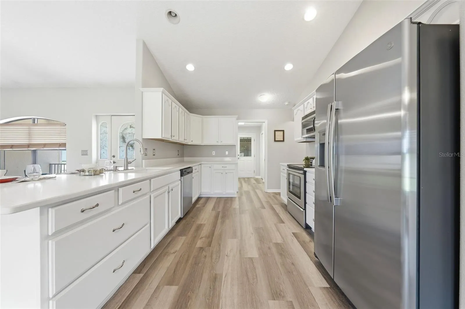 The kitchen is a cook’s delight, featuring an abundance of cabinetry, generous pantry storage, and plenty of space to prepare and entertain with ease.