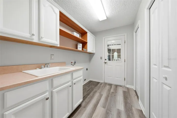 Convenient laundry room located between the kitchen and attached two-car garage for everyday functionality and easy access.