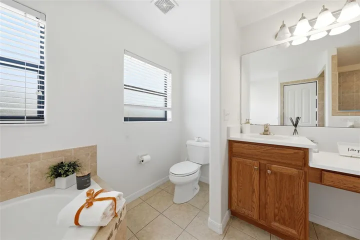 The ensuite bathroom features a relaxing garden tub, walk-in shower, dual his-and-her sinks, and a dedicated vanity area for added comfort and convenience.