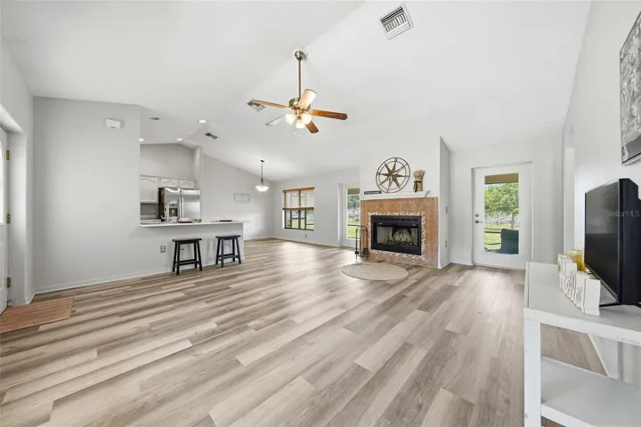 The sprawling living room features beautiful new LVT flooring and a cozy fireplace, creating the perfect space to gather, relax, and unwind after a long day.