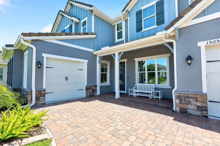 3-car split garage, paver driveway and covered front porch entry.