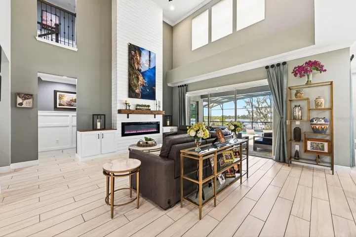 Dramatic two story living room with a built-in fireplace feature wall that adds to the stylish character of this home.