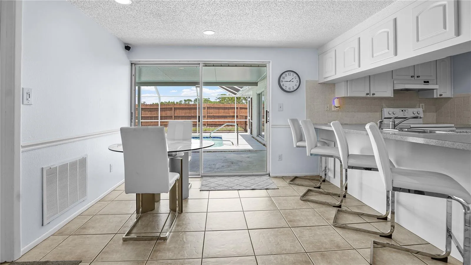 Dining with sliders into covered pool area.