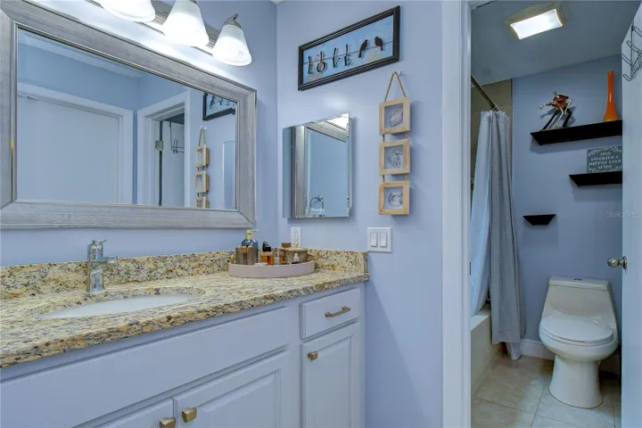 Primary ensuite bathroom with granite countertops and upgraded cabinets