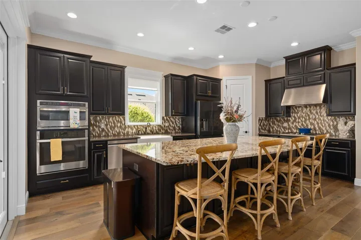 The Gourmet Kitchen Option was selected for the Chef of the home along with the Built-In Stainless Appliances, Apron Kitchen Sink and Raised Panel Cabinetry that wraps the Island. The color coordination is superb with the rich Expresso Cabinet finish.