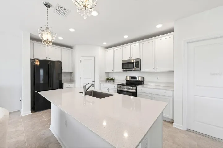The stylish kitchen offers ample cabinetry and storage, sleek countertops, a large center ISLAND with bar seating, and unobstructed sightlines to the living areas and water beyond.