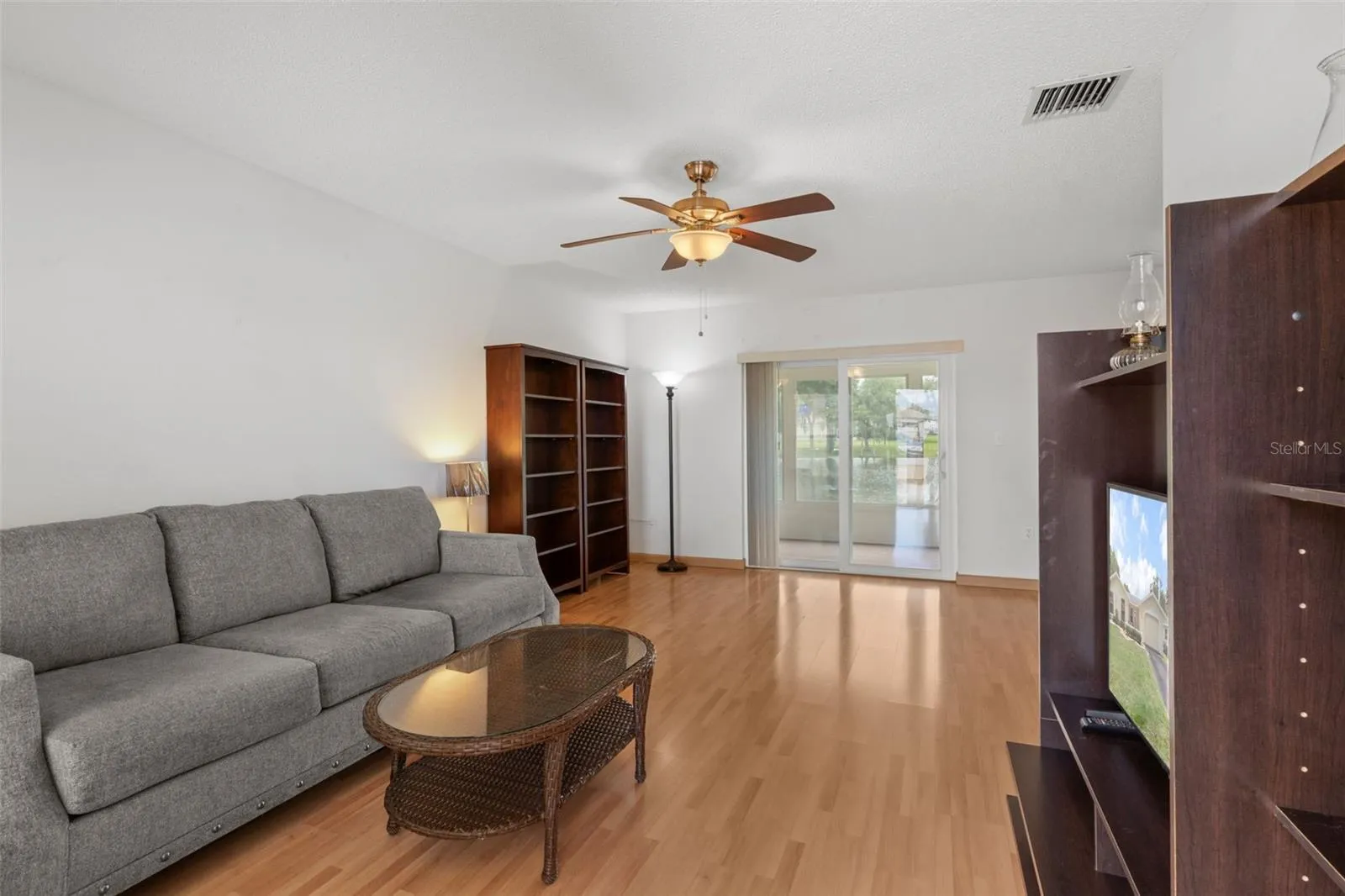 Living Room with Laminate Floors nd Sliders to Enclosed Lanai