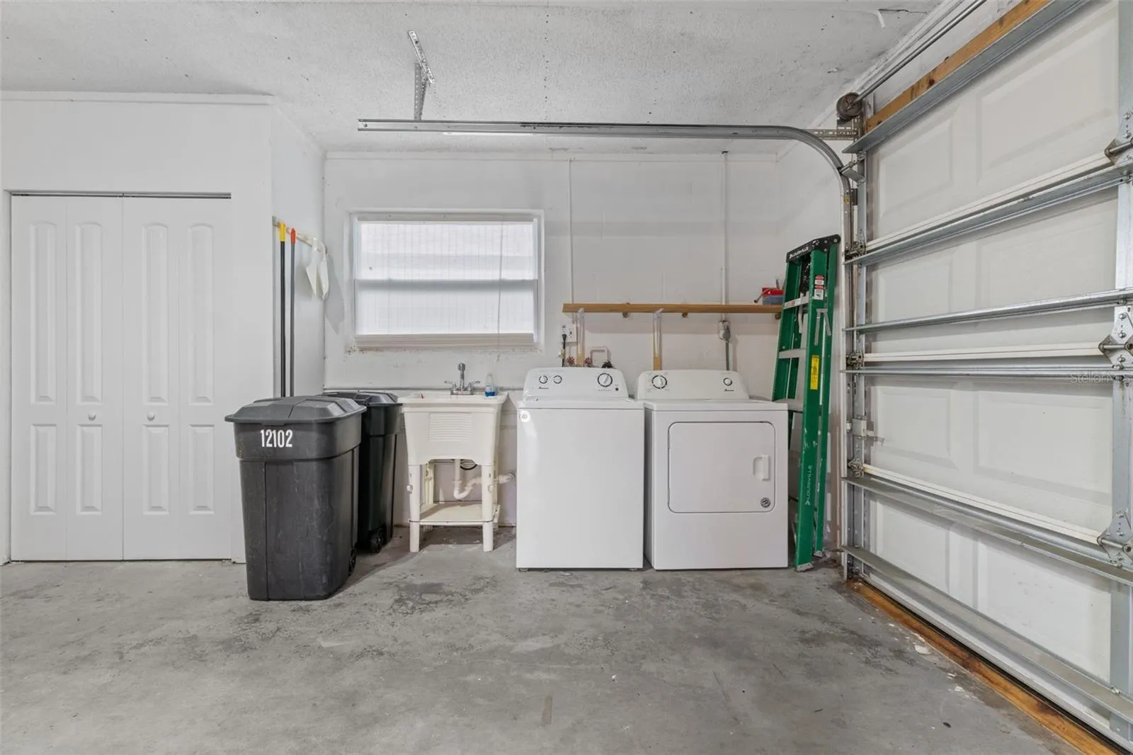 Laundry Area with Storage Closets and Laundry Sink
