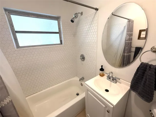 Newer toilet, vanity, mirror and tile surround.