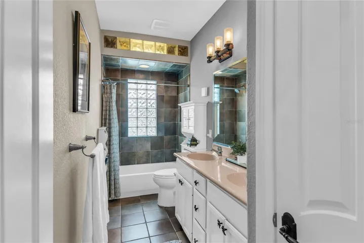 Bathroom 2 with dual sinks, linen closet and shower/tub combo