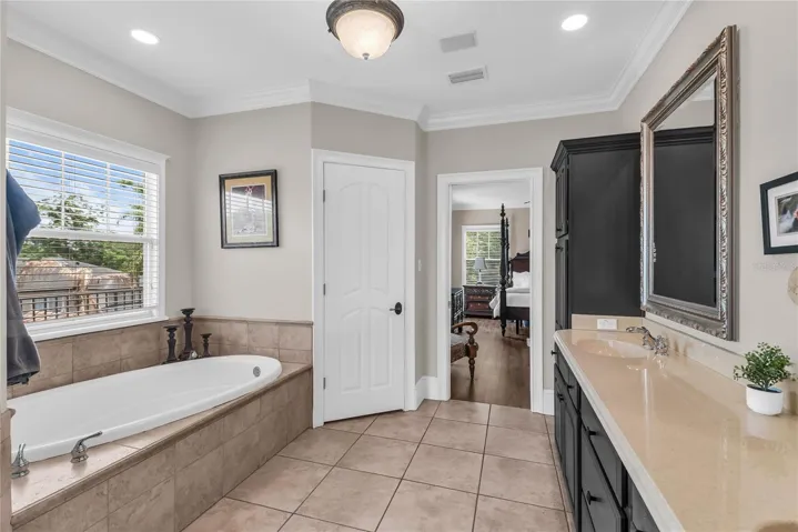 Spacious primary bathroom with dual sinks, toilet closet, soak tub and large walk-in shower