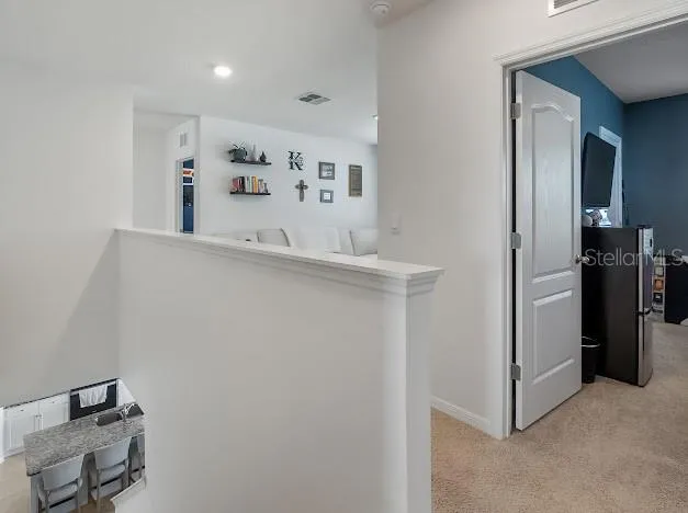 Top of stairs on second floor shows area of laundry room, bedroom access and loft flex space