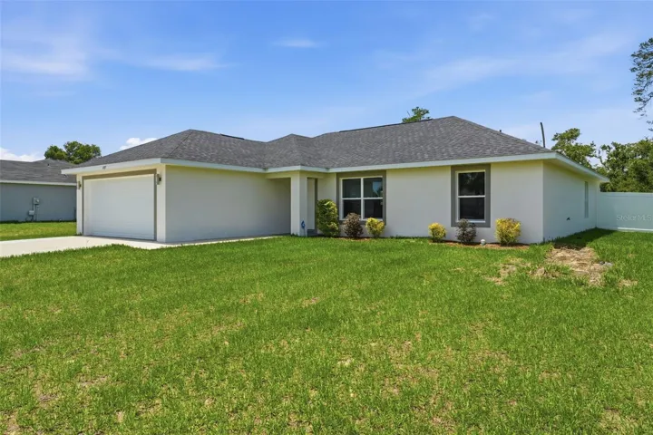 Front elevation featuring low-maintenance newer construction and spacious driveway