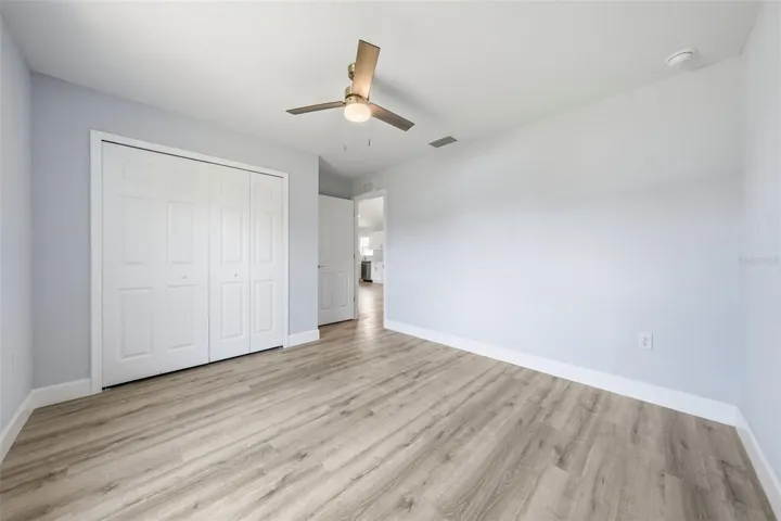 Secondary bedroom with neutral finishes and ceiling fan