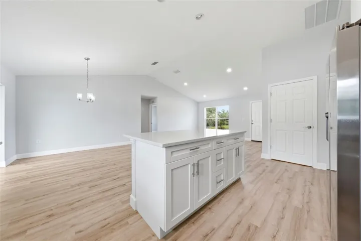 Bright kitchen featuring white shaker cabinetry and large center island