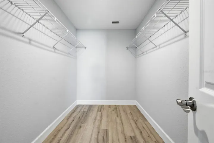 Large walk-in closet with built-in shelving and storage space