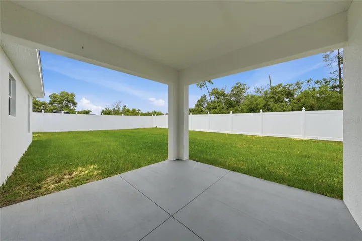 Covered rear patio overlooking the private backyard space