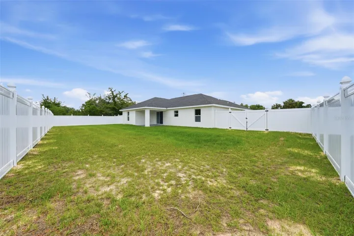 Fully fenced backyard with brand-new white vinyl privacy fencing