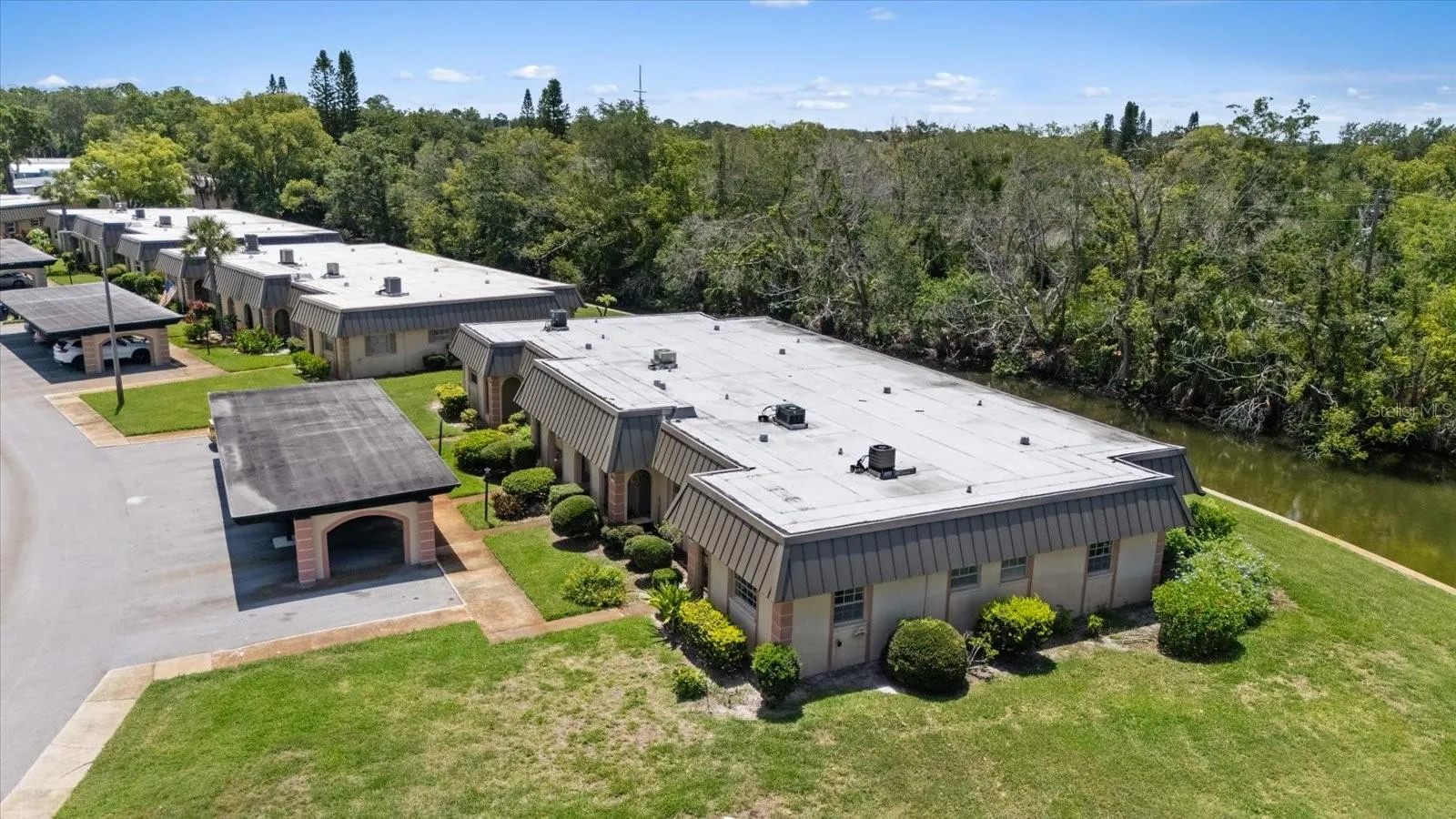 View of side yard and carport with water views behind unit