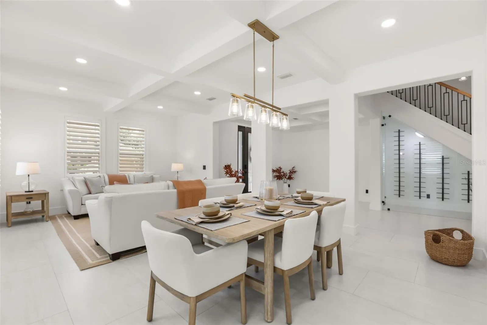 The dining area features a modern linear chandelier, seating for six, and a seamless connection to the living room and foyer.