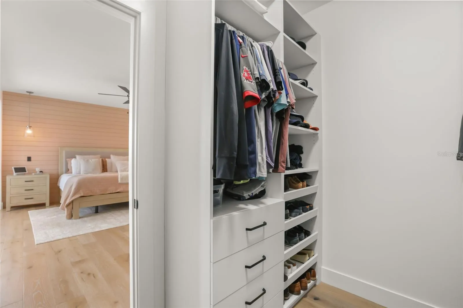 This closet section includes open shelving, drawers, hanging storage, and dedicated shoe storage for a streamlined setup.