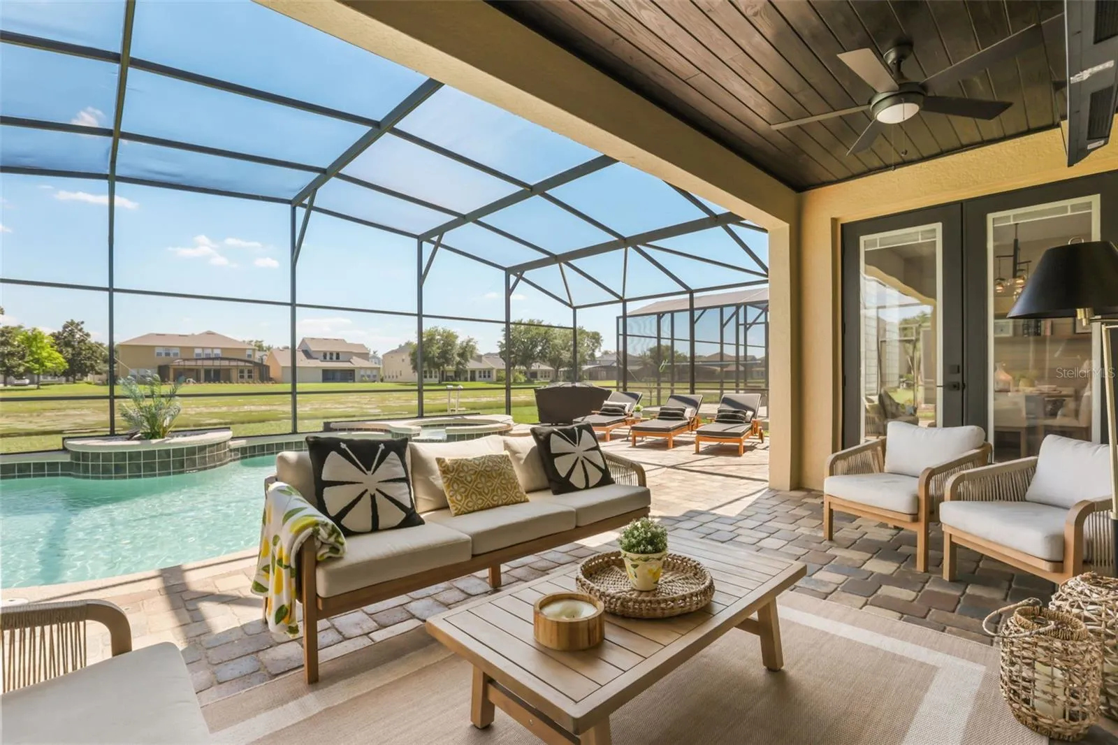 This shaded seating area overlooks the screened pool and spa, creating an inviting indoor-outdoor entertaining space.