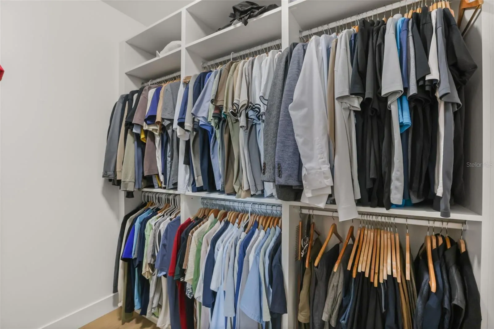 Custom closet built-ins provide abundant hanging space, upper shelving, and organized storage for wardrobe essentials.