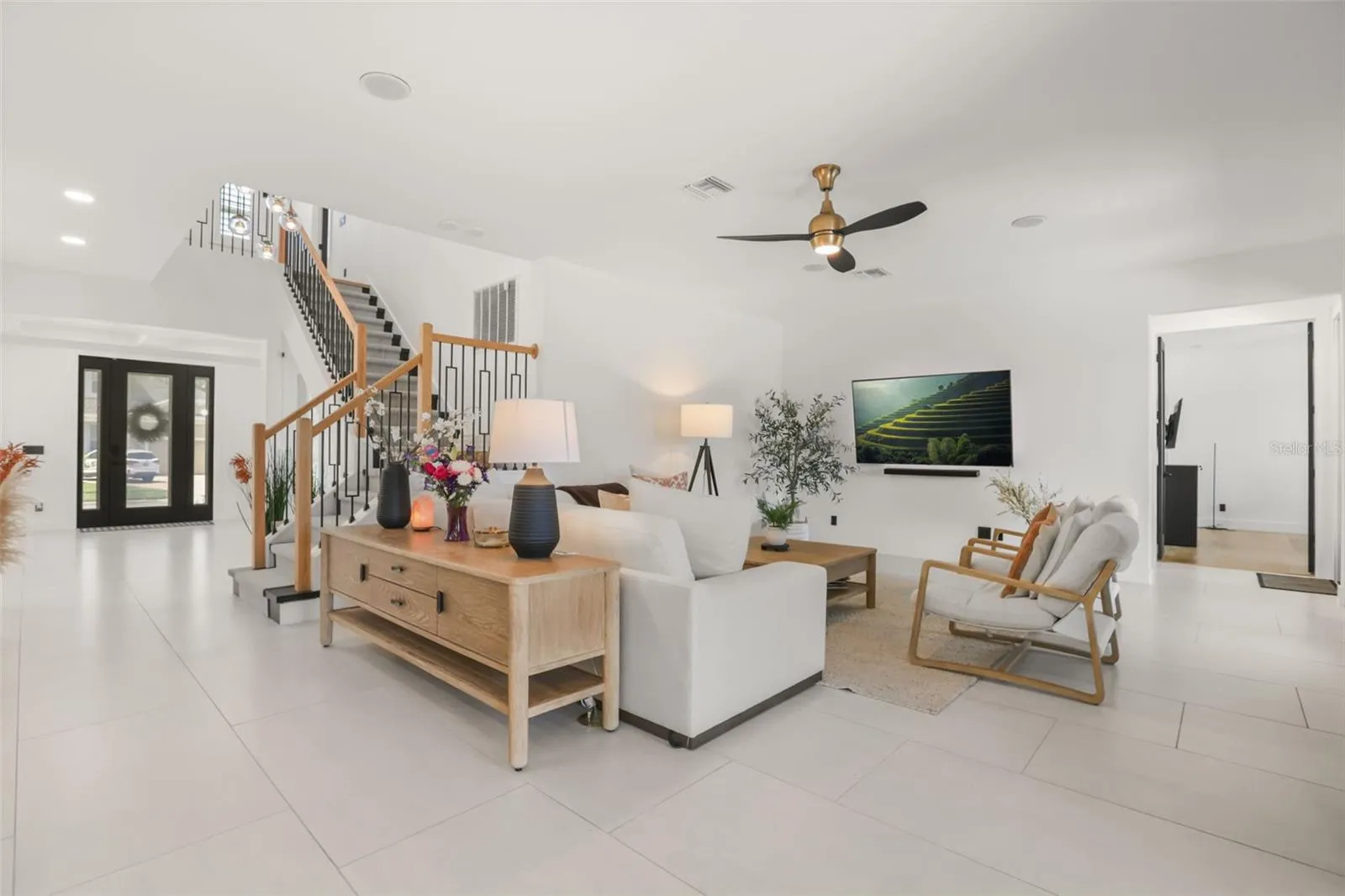 This spacious family room features an open layout, neutral finishes, and easy connection to the foyer and staircase.