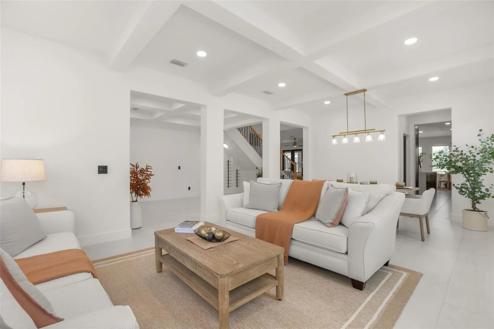 The living area flows easily into the dining space, with tray ceilings, recessed lighting, and open sightlines that enhance the home’s airy feel.