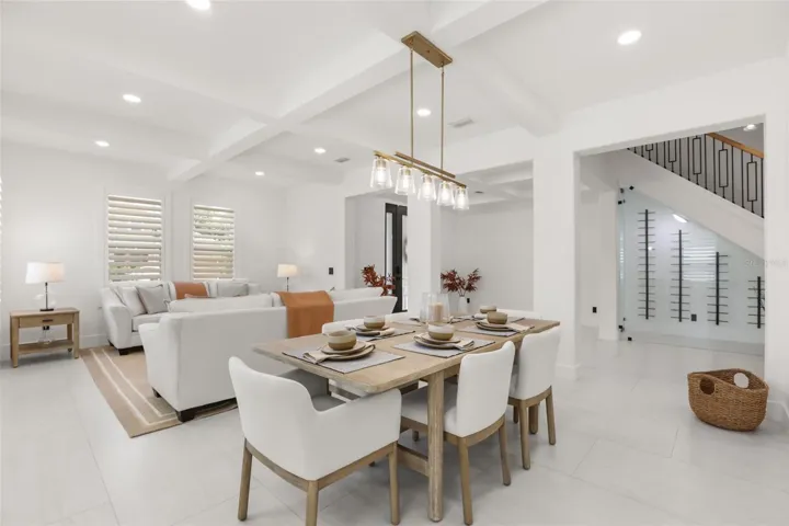 The dining area features a modern linear chandelier, seating for six, and a seamless connection to the living room and foyer.