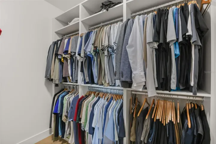 Custom closet built-ins provide abundant hanging space, upper shelving, and organized storage for wardrobe essentials.