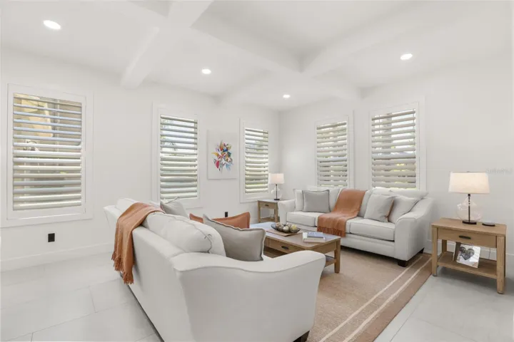 This inviting sitting area features plantation shutters, soft neutral finishes, and abundant natural light for a comfortable gathering space.