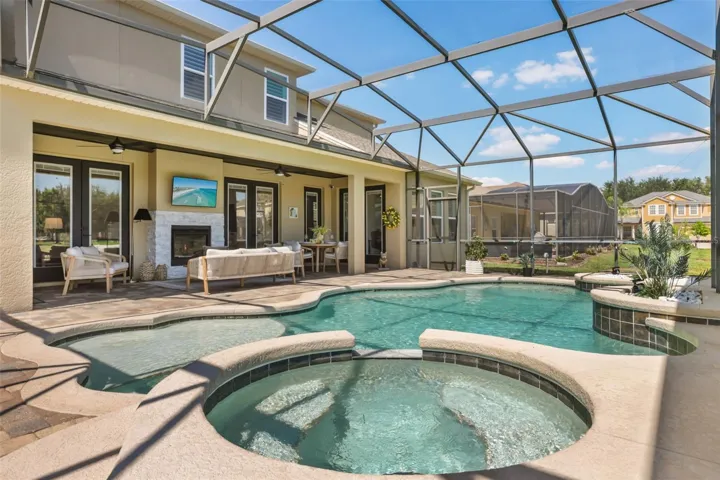A screened outdoor retreat features a pool, raised spa, paver deck, and covered lanai for comfortable outdoor living.