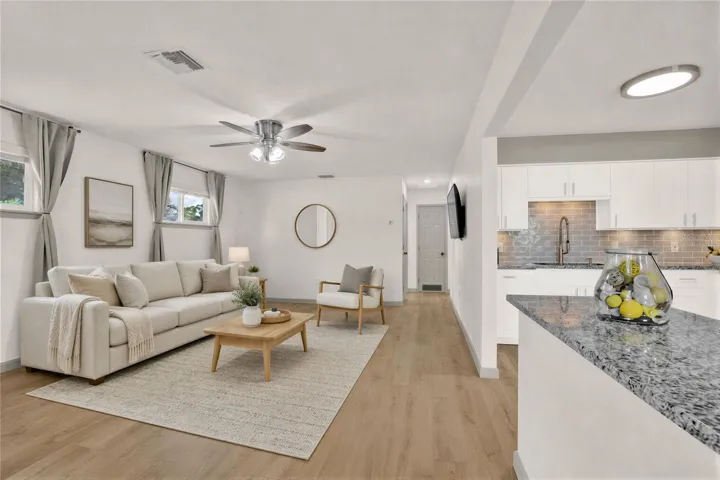Virtually staged: Living Room with luxury vinyl planks (LVP), curtains, overhead fan.