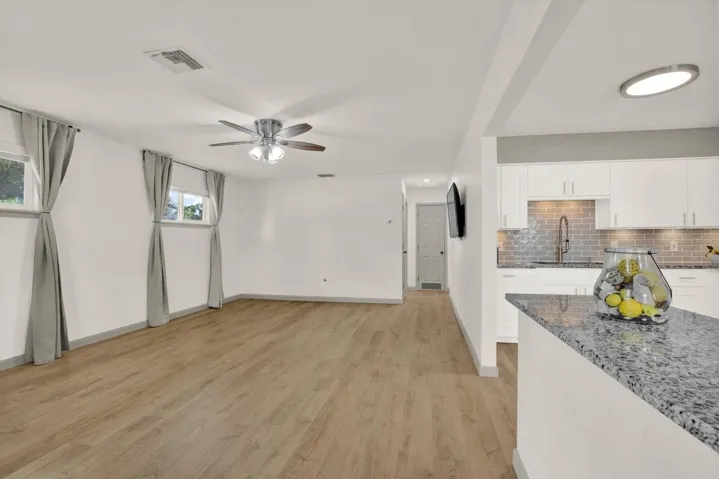 Living Room with luxury vinyl planks (LVP), curtains, overhead fan