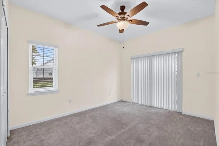 Downstairs bedroom 1 with sliding glass door to patio.