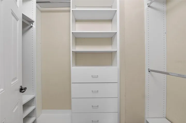 Primary bedroom closet with built ins.