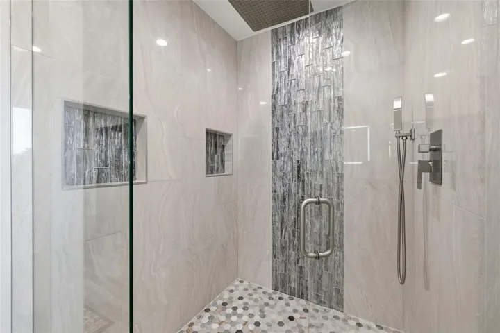 Primary En Suite Walk in Shower! Marble Floor, Travertine Walls! Integrated Rain Shower head! Frameless Glass Enclosure has been treated with anti spotting glass.