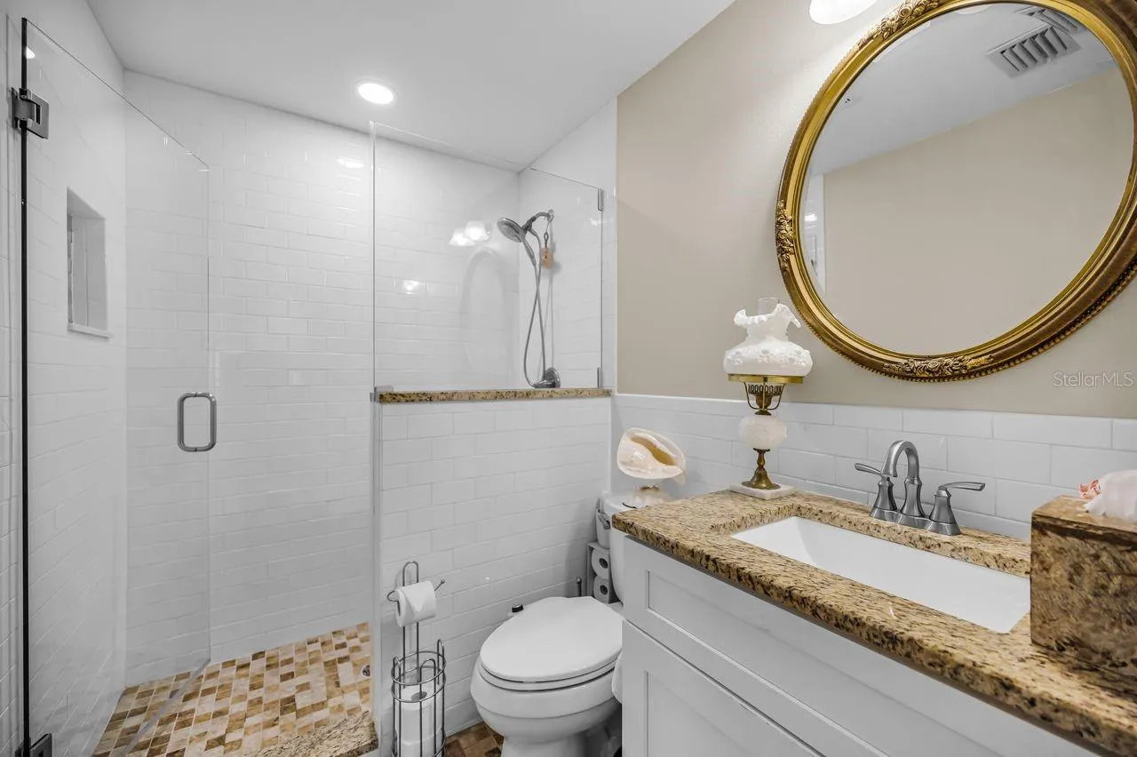 Walk-in shower, granite top and tiled flooring.