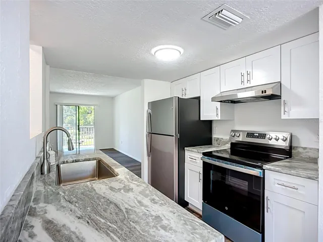 Nice solid surface counters, stainless steel appliances, and white cabinets.