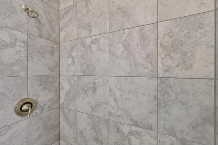 Neutral tile in shower, single lever easy to use shower fixtures ~