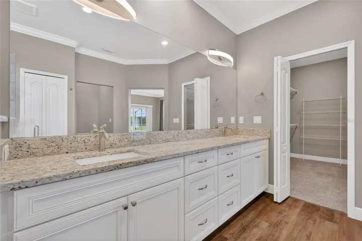 Gleaming granite counters over the raised dual vanities ~