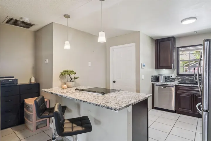 Renovated kitchen with Stainless Steel Appliances, Granite countertops, breakfast bar with pendant lighting,