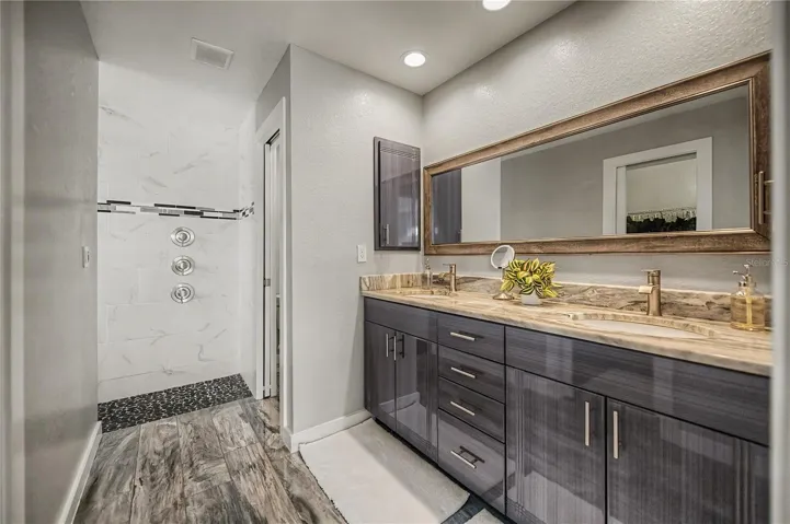 Primary Ensuite Featuring Dual Vanities, Designer Finishes, and a Spa-Style Walk-In Shower.