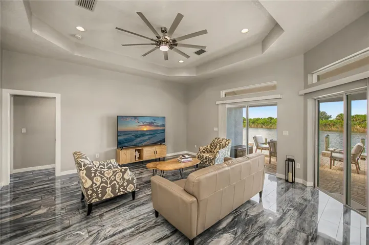 Living Rooms has Soaring Tray Ceilings, Designer Flooring, and Seamless Access to the Waterfront Patio.