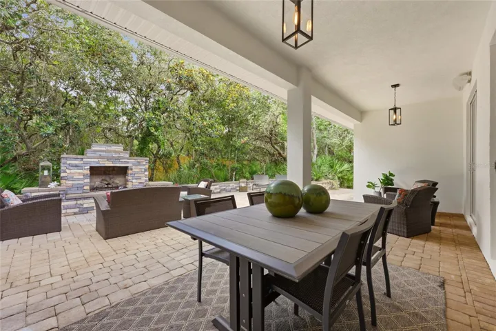 Substantial 56’ x 28 paver outdoor living area with built-in fireplace and private outdoor shower, perfect for relaxing or entertaining.