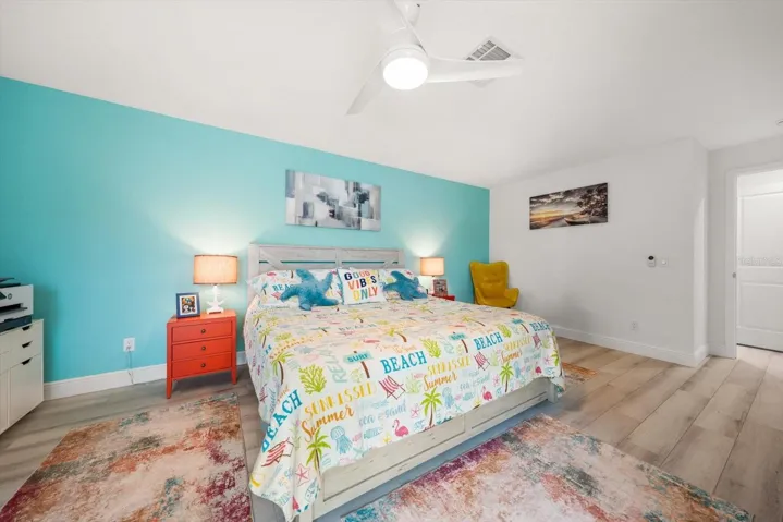 Bright guest bedroom featuring a spacious king-sized bed and vibrant, brilliant color accents.