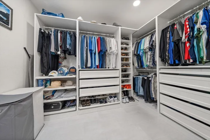 Custom-built walk-in closet with tons of storage, floor-to-ceiling shoe racks, and a cool velvet-lined jewelry drawer. Everything is perfectly organized and has its own spot in this dream closet.